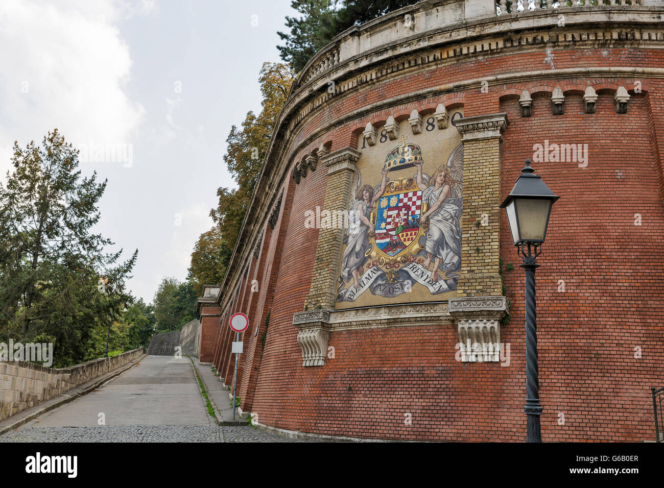 Road to Royal Palace with ancient mosaic Coat of Arms on Castle Hill wall in Budapest, Hungary. Stock Photo