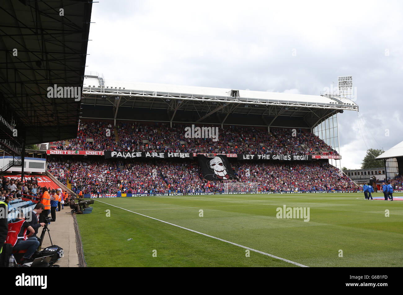 General view as a banner bearing the face of Billy the Puppet from the Saw movies is held in the stands at Selhurst Park Stock Photo