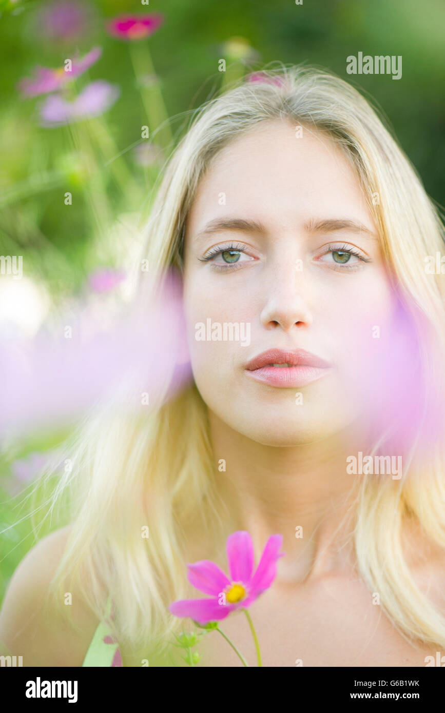 Young woman among cosmos flowers, portrait Stock Photo