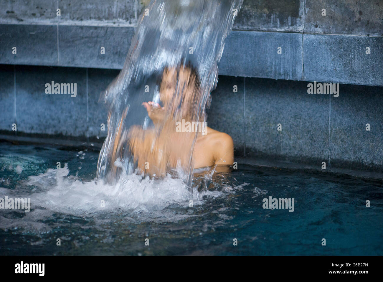 Woman behind waterfall in spa Stock Photo