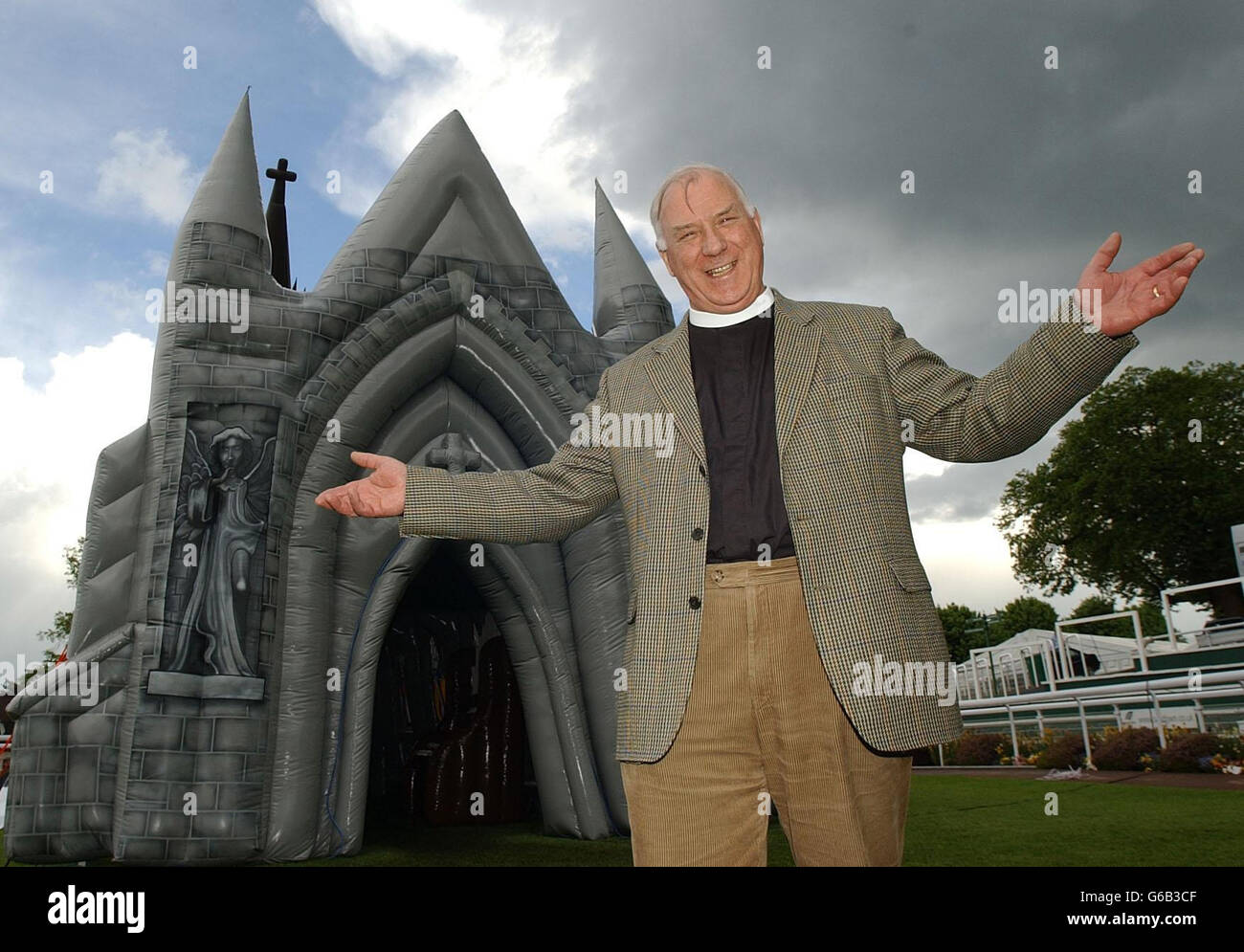 Vicar Chris Keating from All Saints church in Good Meyes, Essex, stands by the world's first inflatible church which went on display , at the Christian Resources Exhibition at Sandown Park Exhibition Centre, Surrey. The PVC church, which is 47ft high from ground to steeple, *..47ft long and 25ft wide, resembles a giant bouncy castle, holds around 60 people standing and includes a blow-up organ, altar, pulpit, pews, candles and 'stained glass' windows. Stock Photo