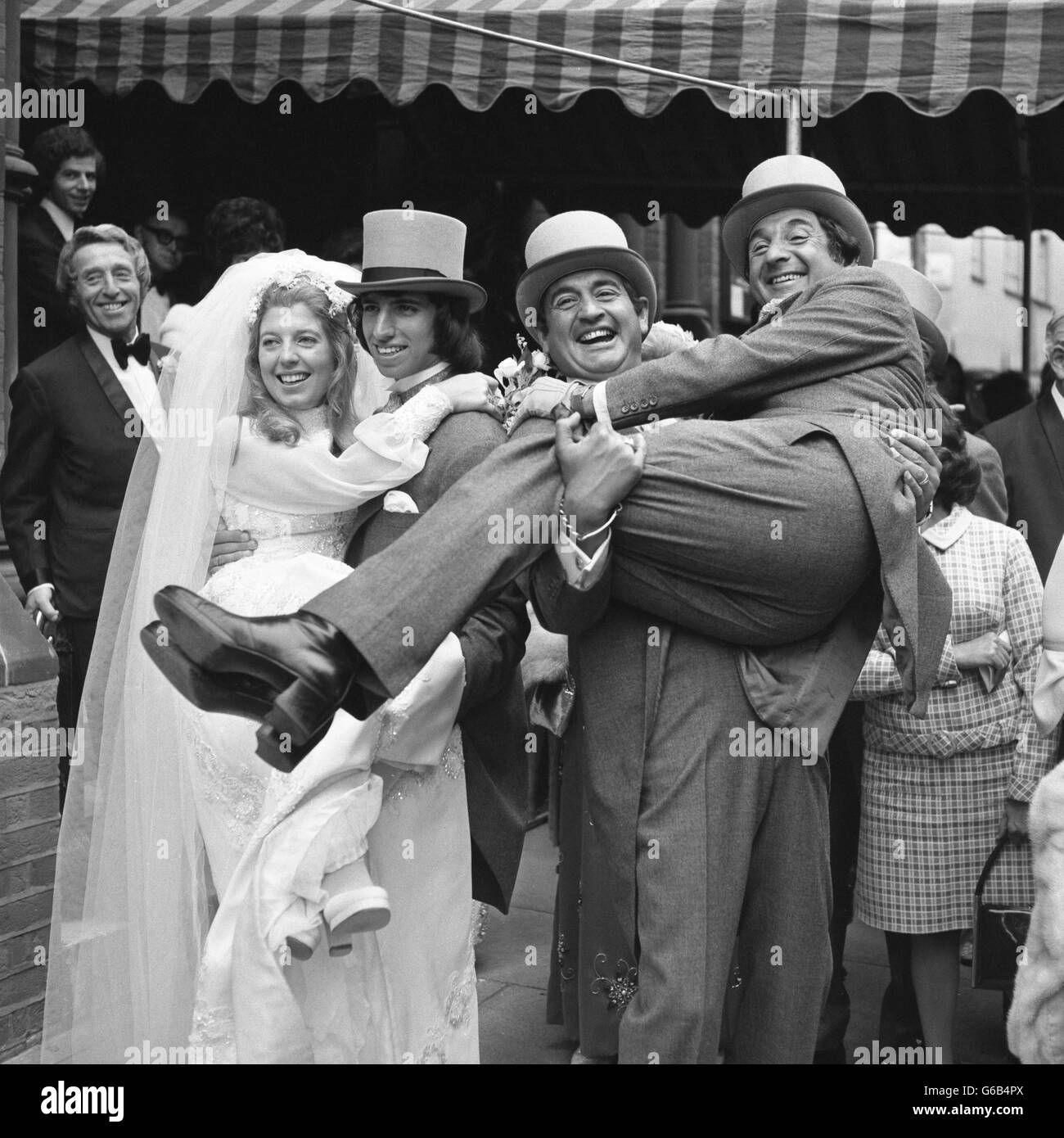 Mike Winters is lifted by brother Bernie, as the bride Beverley Wise - their niece - is lifted by groom Lawrence Swycher. They married at the West End Synagogue in St Petersburgh Place, London. Stock Photo