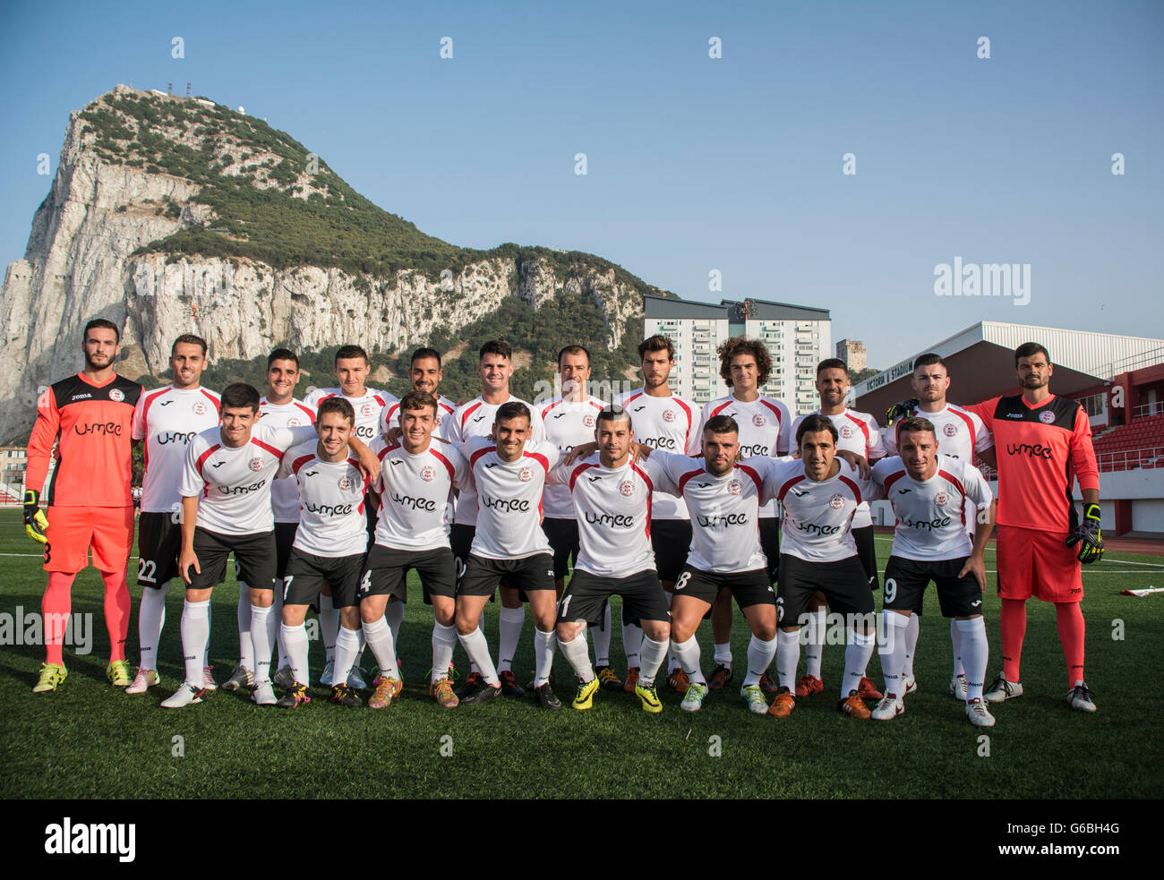 Gibraltar - 24th June 2016 - Pictured the full squad of Gibraltar's 2015/16 league champions Lincoln Red Imps FC who will be travelling to Estonia this weekend to play against Flora Tallinn (EST) in the first round qualifying first leg match of the UEFA Champions League on Tuesday 28th June 2016. Pictured with the latest squad at the Victoria Stadium with the Rock of Gibraltar in the background.Lincoln REd Imps are wearing their new stripe after signing up a new sponsor. Credit:  Stephen Ignacio/Alamy Live News Stock Photo