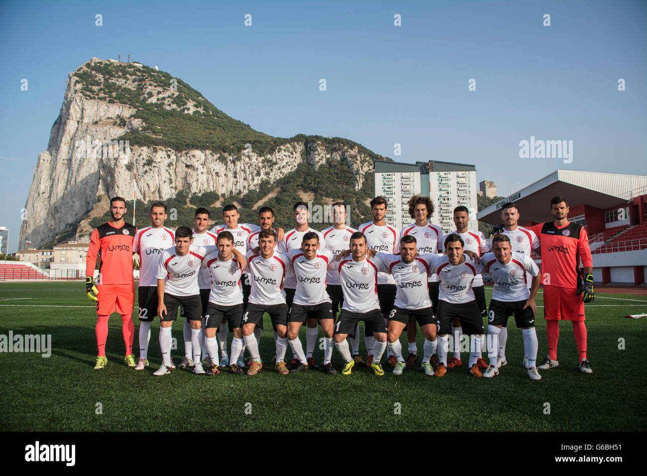 Gibraltar - 24th June 2016 - Pictured the full squad of Gibraltar's 2015/16 league champions Lincoln Red Imps FC who will be travelling to Estonia this weekend to play against Flora Tallinn (EST) in the first round qualifying first leg match of the UEFA Champions League on Tuesday 28th June 2016. Pictured with the latest squad at the Victoria Stadium with the Rock of Gibraltar in the background.Lincoln REd Imps are wearing their new stripe after signing up a new sponsor. Credit:  Stephen Ignacio/Alamy Live News Stock Photo