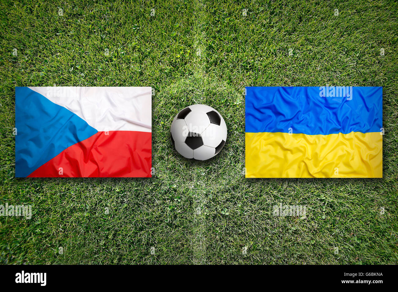 Czech Republic vs. Ukraine flags on green soccer field Stock Photo