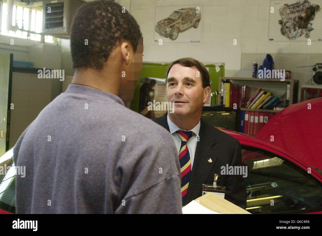 Former Formula 1 racing driver Nigel Mansell talks to a young offender inside Feltham Young Offenders Institute in Feltham, south-west London. Mansell, who is President of UK Youth, * .. was visiting the institute to hand out awards to young offenders who have excelled in NVQ's, Duke of Edinburgh Bronze Awards and on Ford apprenticeships which see the young men learning skills relating to the motor industry. Stock Photo