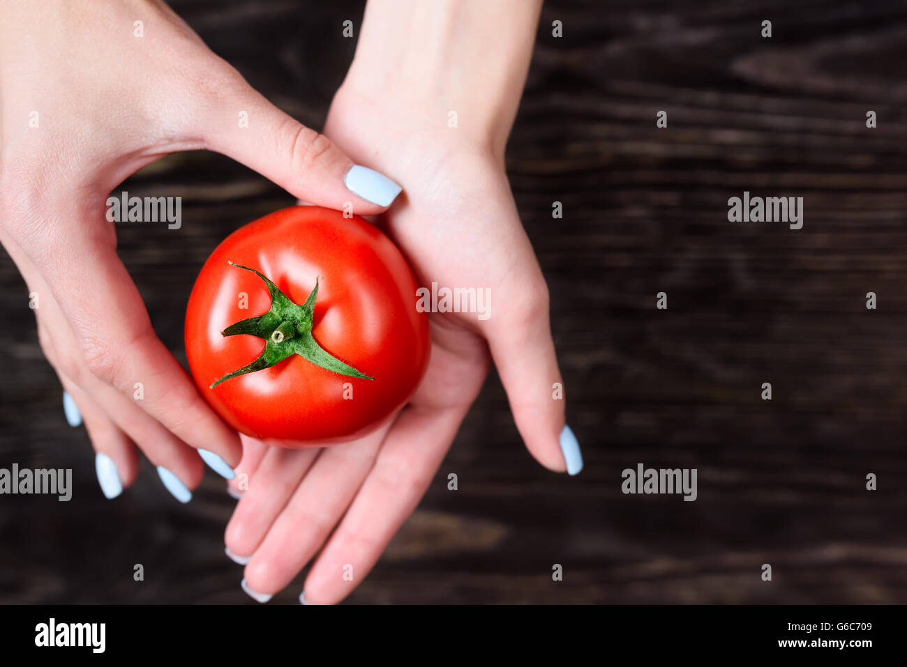 The girl in the hands holding a tomato Stock Photo - Alamy
