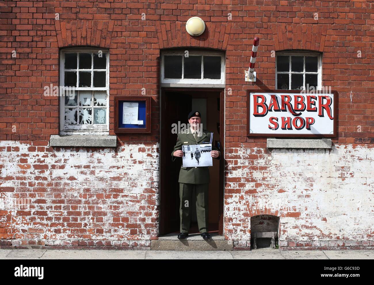 Barracks Barber Private Noel McDonnell, pictured outside his shop