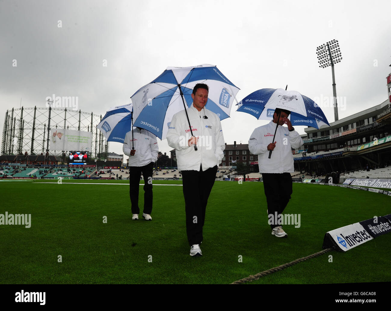 Cricket umpires Richard Kettleborough (left) and Aleem Dar (right) check on  the state of the pitch during day four of the Fifth Investec Ashes Test  match at The Kia Oval, London Stock