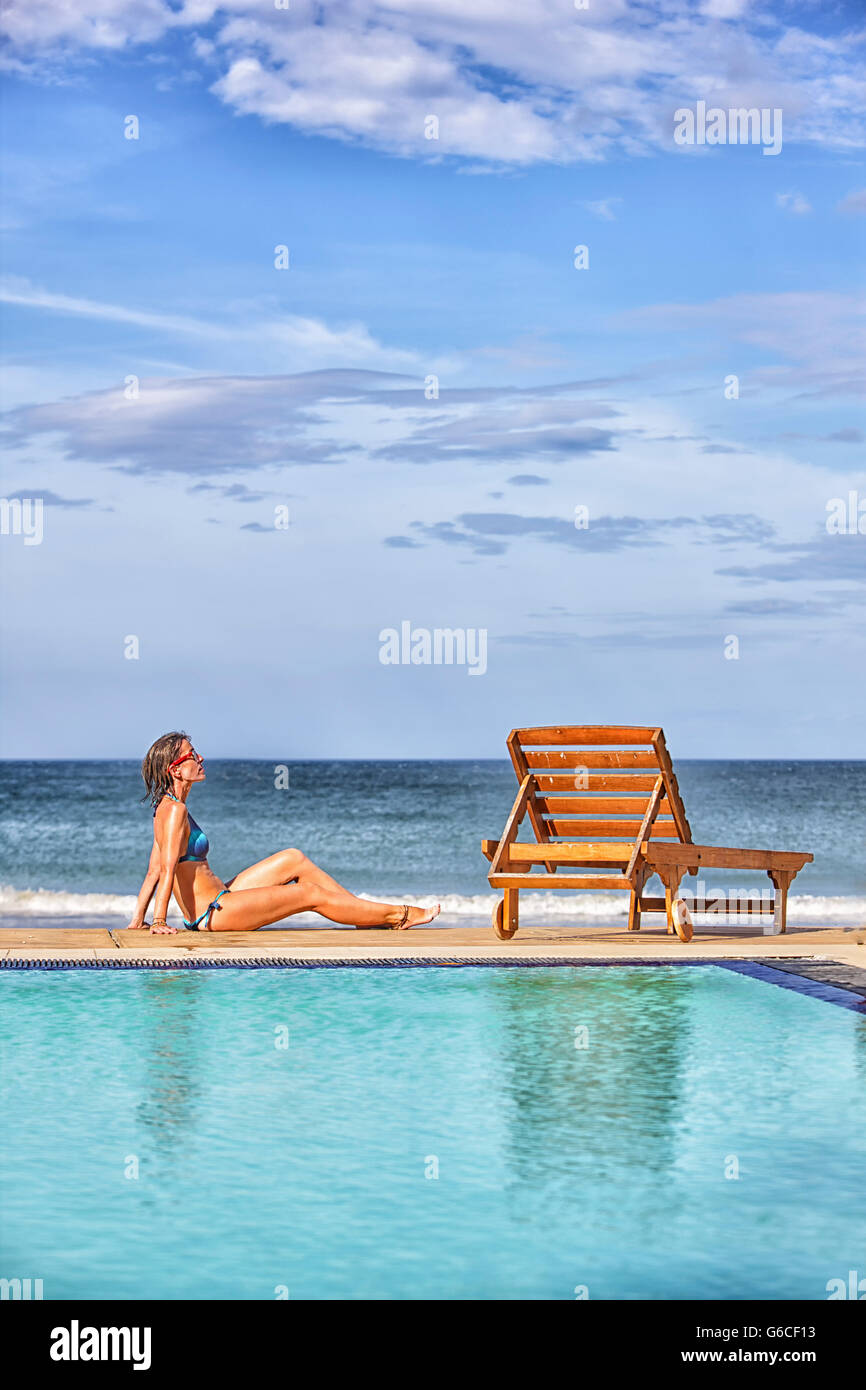 Woman sunbathing by a pool in Nilaveli. Sri Lanka Stock Photo