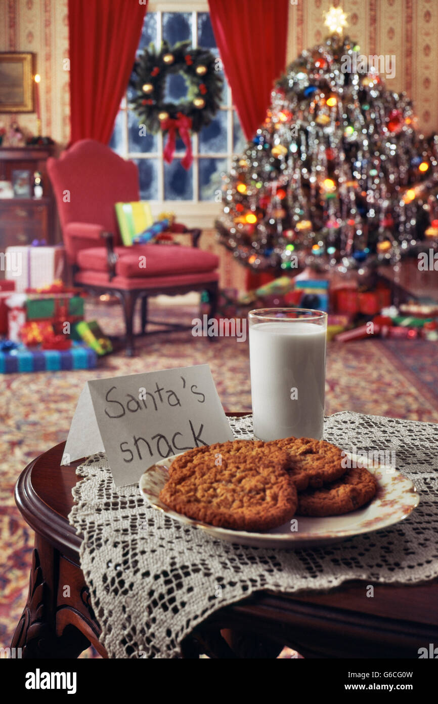 1970s CHRISTMAS INDOOR LIVING ROOM WITH TREE TOYS PRESENTS AND COOKIES AND MILK SNACK FOR SANTA CLAUS Stock Photo