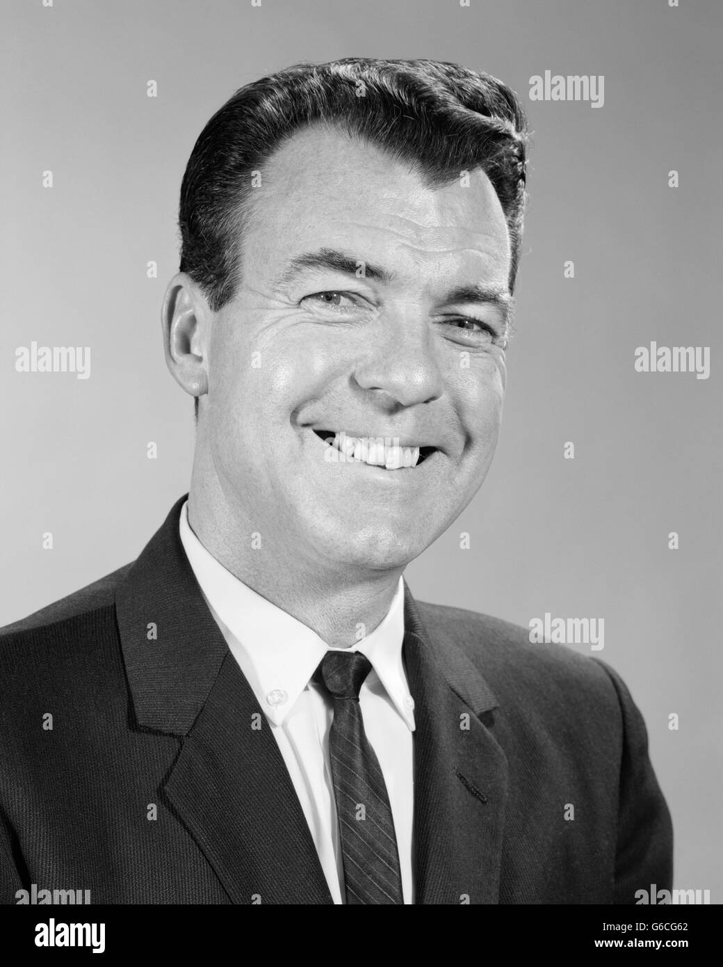 1960s SMILING BUSINESS MAN PORTRAIT WEARING SUIT TIE LOOKING AT CAMERA Stock Photo