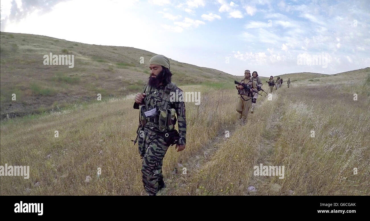 Islamic State fighters with the Storming Battalion on the march to attempt for the second time to capture Peshmerga Kurdish positions North of Mosul May 3, 2016 near Tesqopa, Iraq. The still image is captured from a propaganda video released by the Islamic State of Iraq and the Levant. Stock Photo