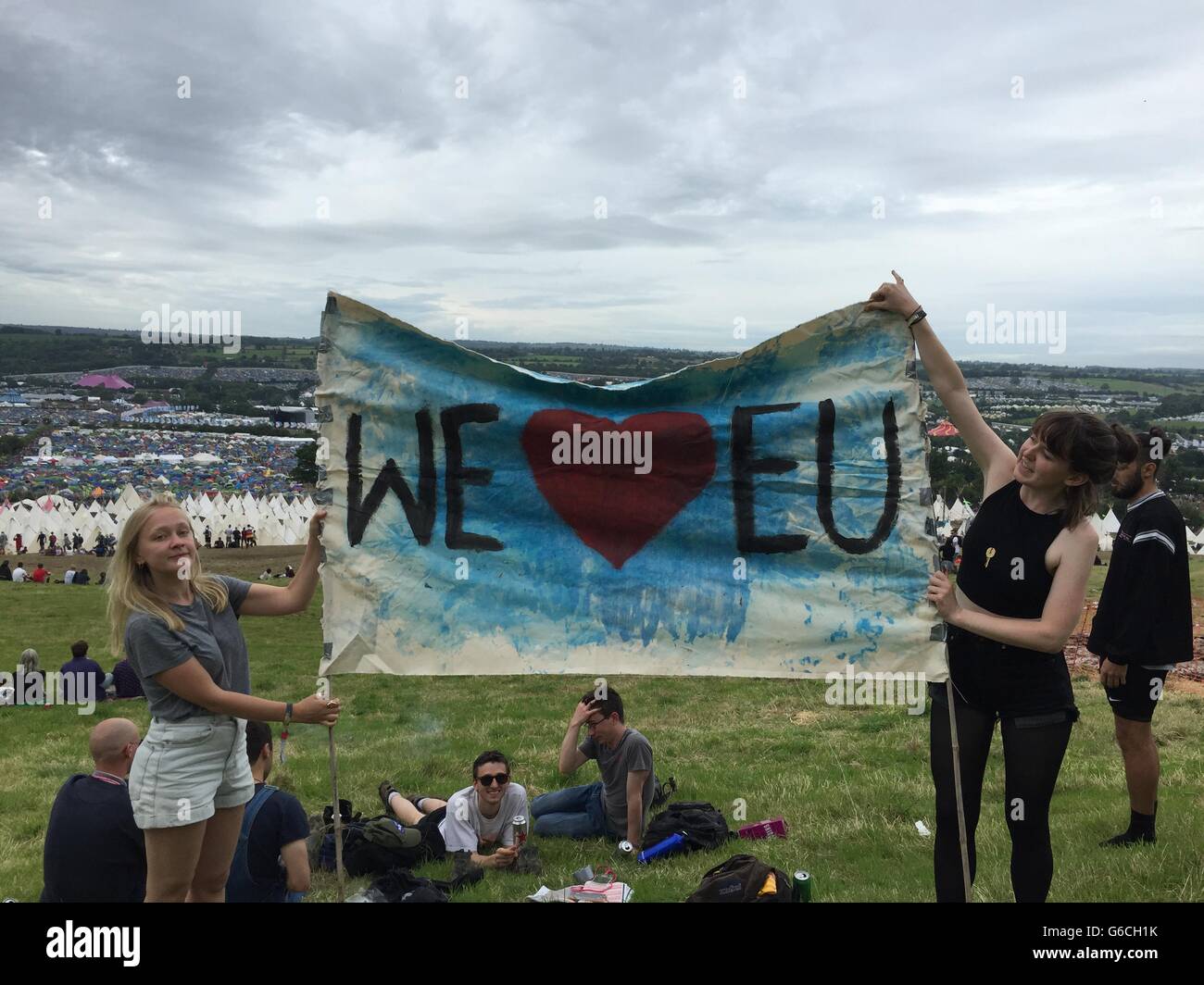 Sophie Chapman (left) and Phillipa Taylor hold a banner declaring their love for the EU at the Glastonbury festival in Somerset. Stock Photo