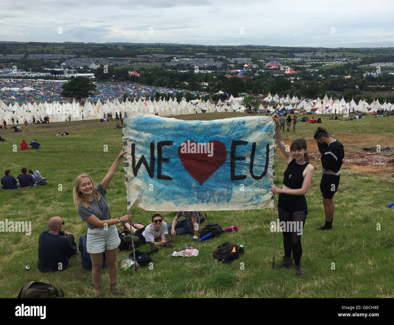 Sophie Chapman (left) and Phillipa Taylor hold a banner declaring their love for the EU at the Glastonbury festival in Somerset. Stock Photo