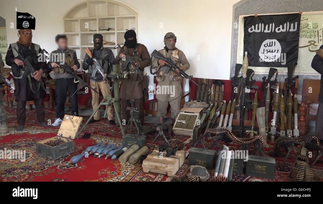 Islamic State fighters pose with captured weapons after over running an Iraqi outpost April 4, 2016 in the vicinity of Zawbaa, Iraq. The still image is captured from a propaganda video released by the Islamic State of Iraq and the Levant. Stock Photo