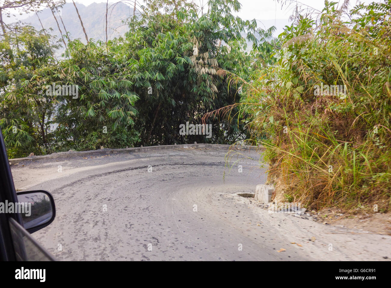 View from car passenger seat - Approaching a right hairpin bend on a steep descending road en route to Pelling from Darjeeling Stock Photo