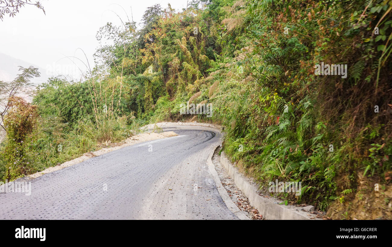 Typical narrow, curvy road in Darjeeling without traffic barriers. Stock Photo