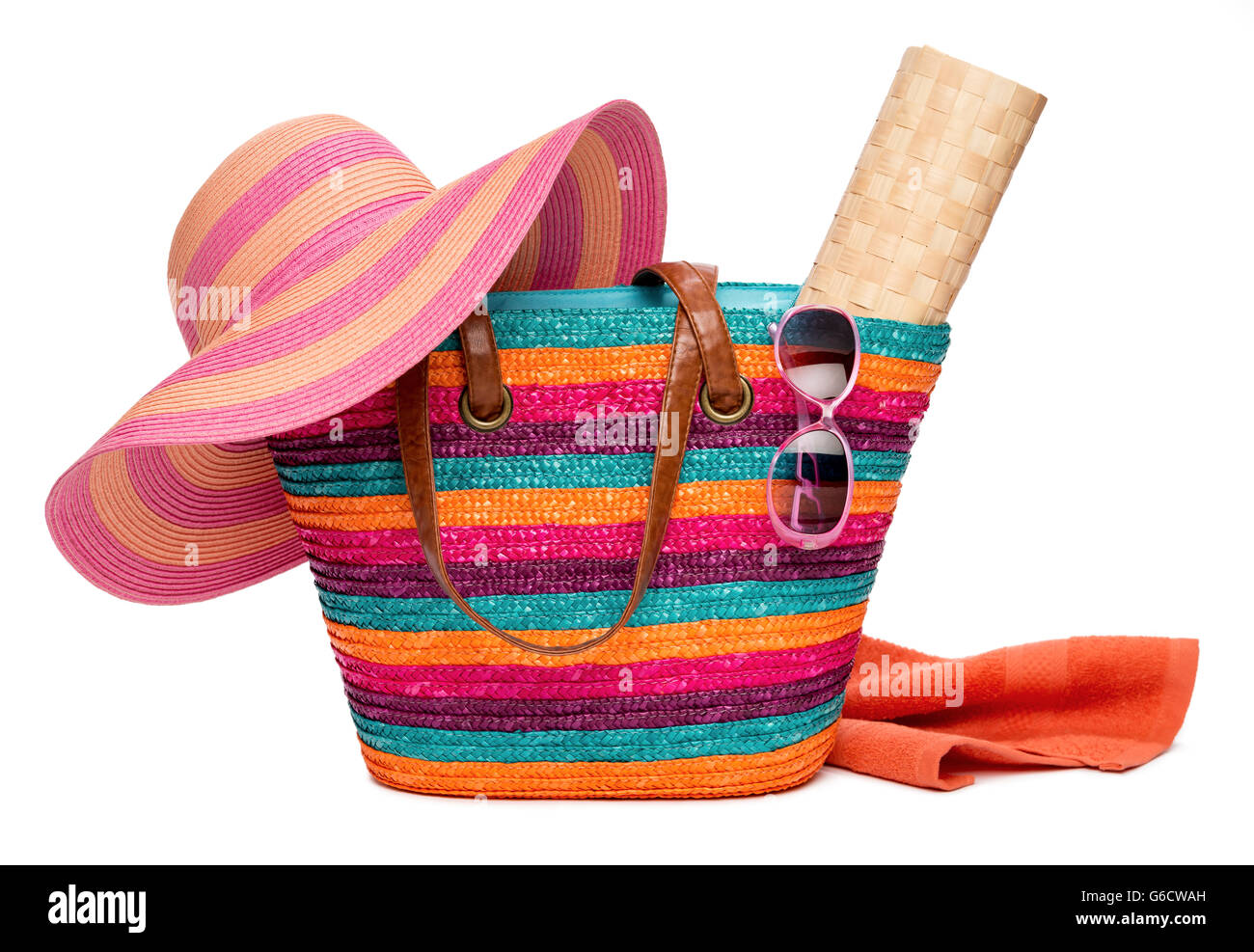 Colorful striped beach bag with a straw hat sun mat towel and sunglasses Stock Photo