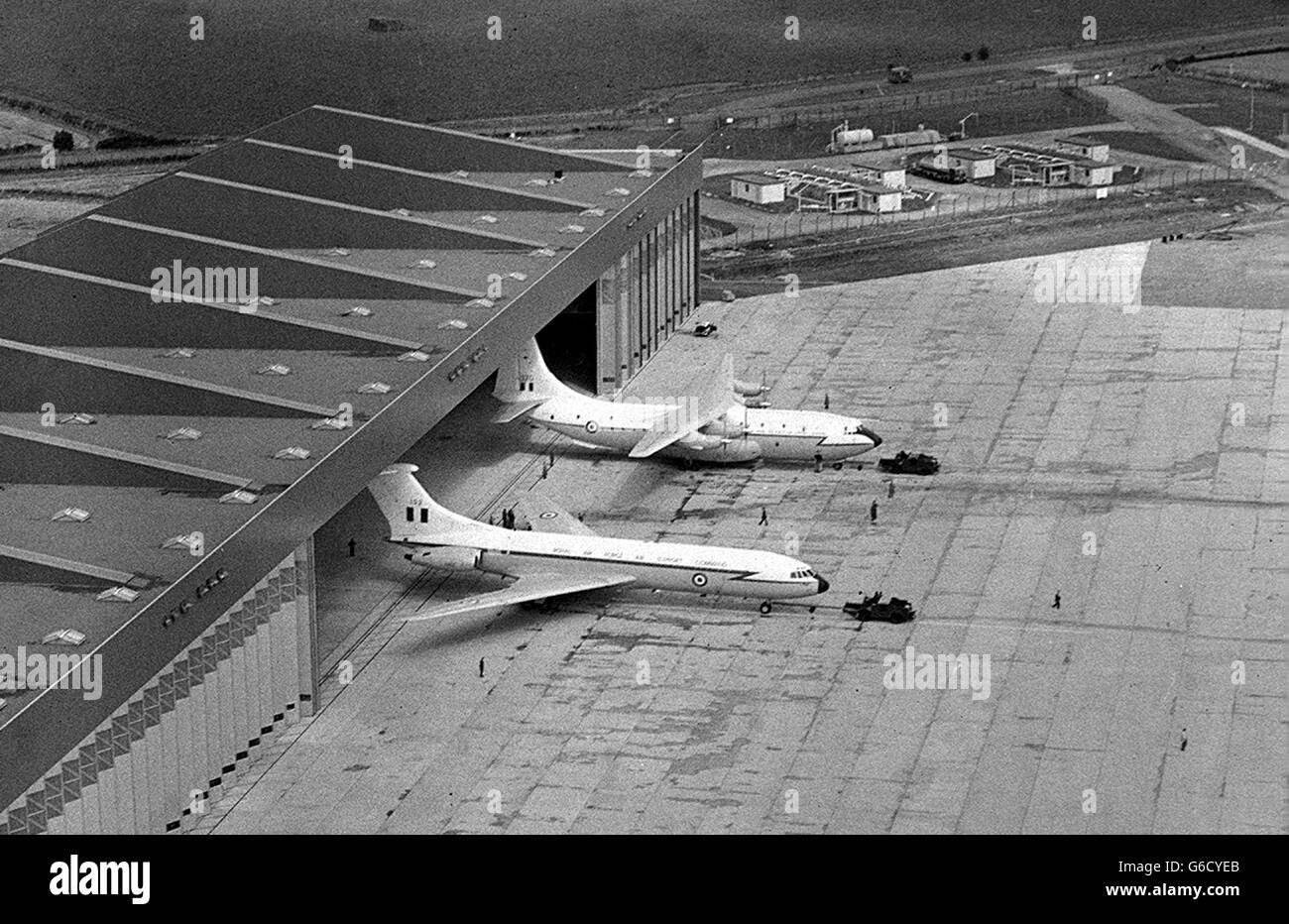 A VC 10 jet transporter (in front) and a Belfast turbojet freighter (behind) are seen outside the gigantic new hangar, one of the biggest in Western Europe, officially handed over to the Royal Aor Force at Brize Norton, Oxfordshire, by Sir Cecil Mant, Controller-General of the Ministry of Public Buildings and Works. The hangar, 1,056ft. long, 215ft. wide and 90ft. high, covers five acres and is capable of holding three 144-ton VC 10's and three 100-ton Belfasts. It has cost 1,800,000 and marks another stage in the development of Brize Norton as the main base for the strategic force of RAF Air Stock Photo