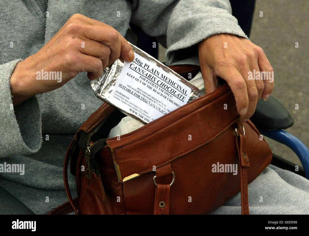 Elizabeth Ivol, who is also known as Biz, arriving at Kirkwall Sheriff Court on Orkney, holds aloft a bar of cannabis chocolate. Ivol, 55, of South Ronaldsay, a wheelchair-confined multiple sclerosis sufferer, denies three charges in relation to the handling of cannabis. Stock Photo