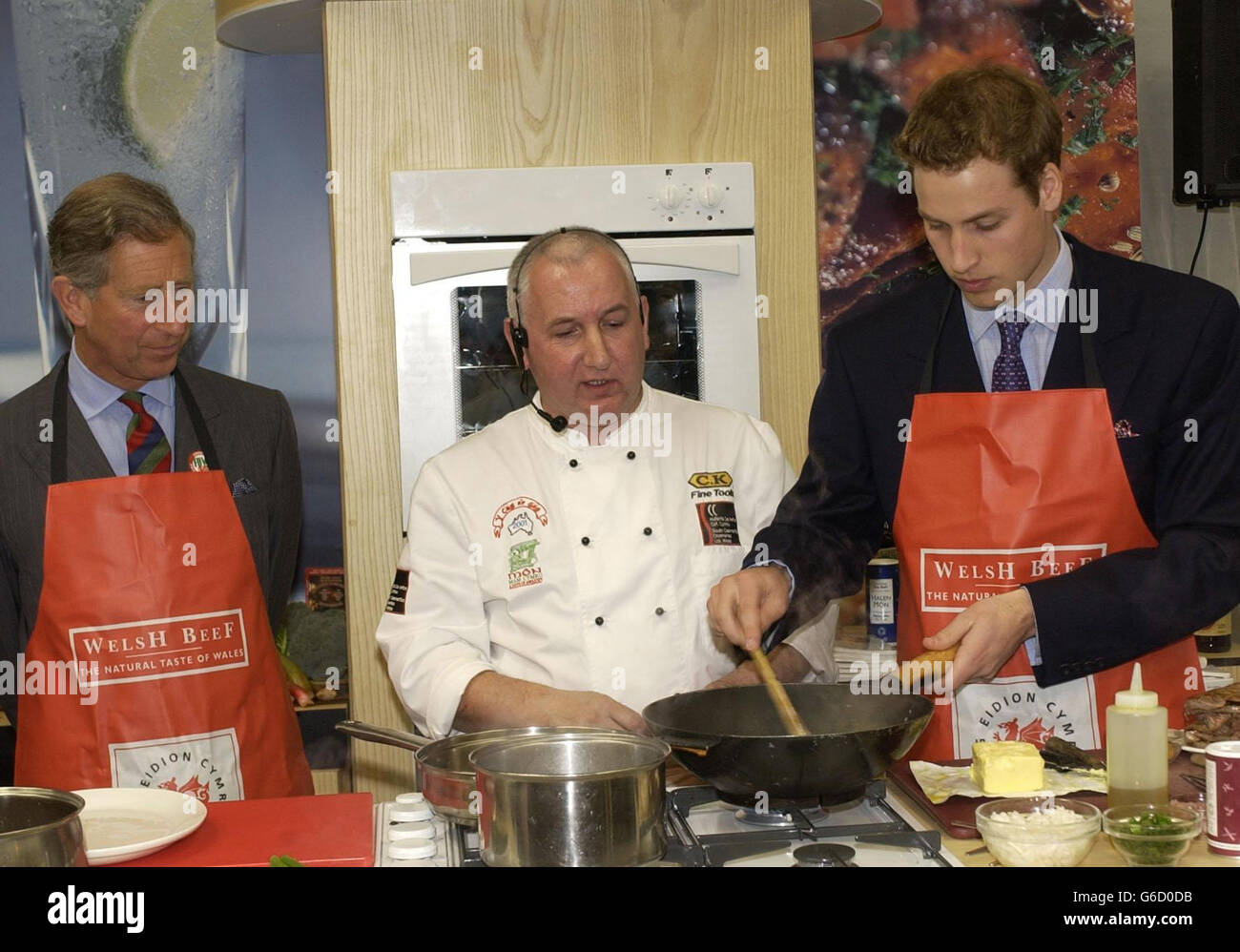 Prince William displays his cookery skills using a wok as his father, the Prince of Wales watches over the cookery presentation, during their visit to the Anglesey Food fair, at the Anglesey Agricultural Showground. Stock Photo