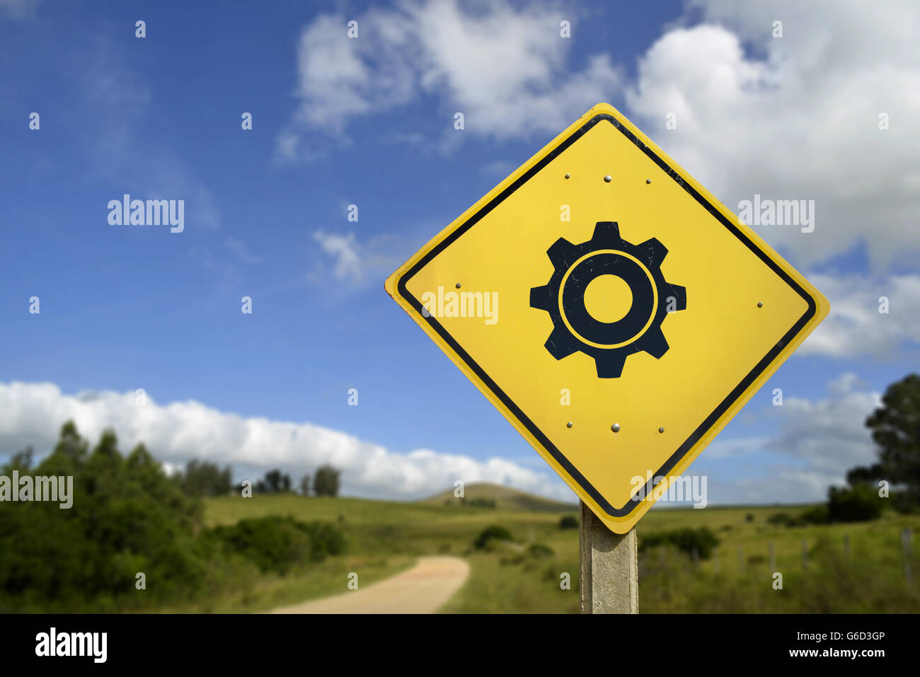 Access to support in rural area concept. Road sign with gear wheel icon on nature environment, includes copy space. Stock Photo