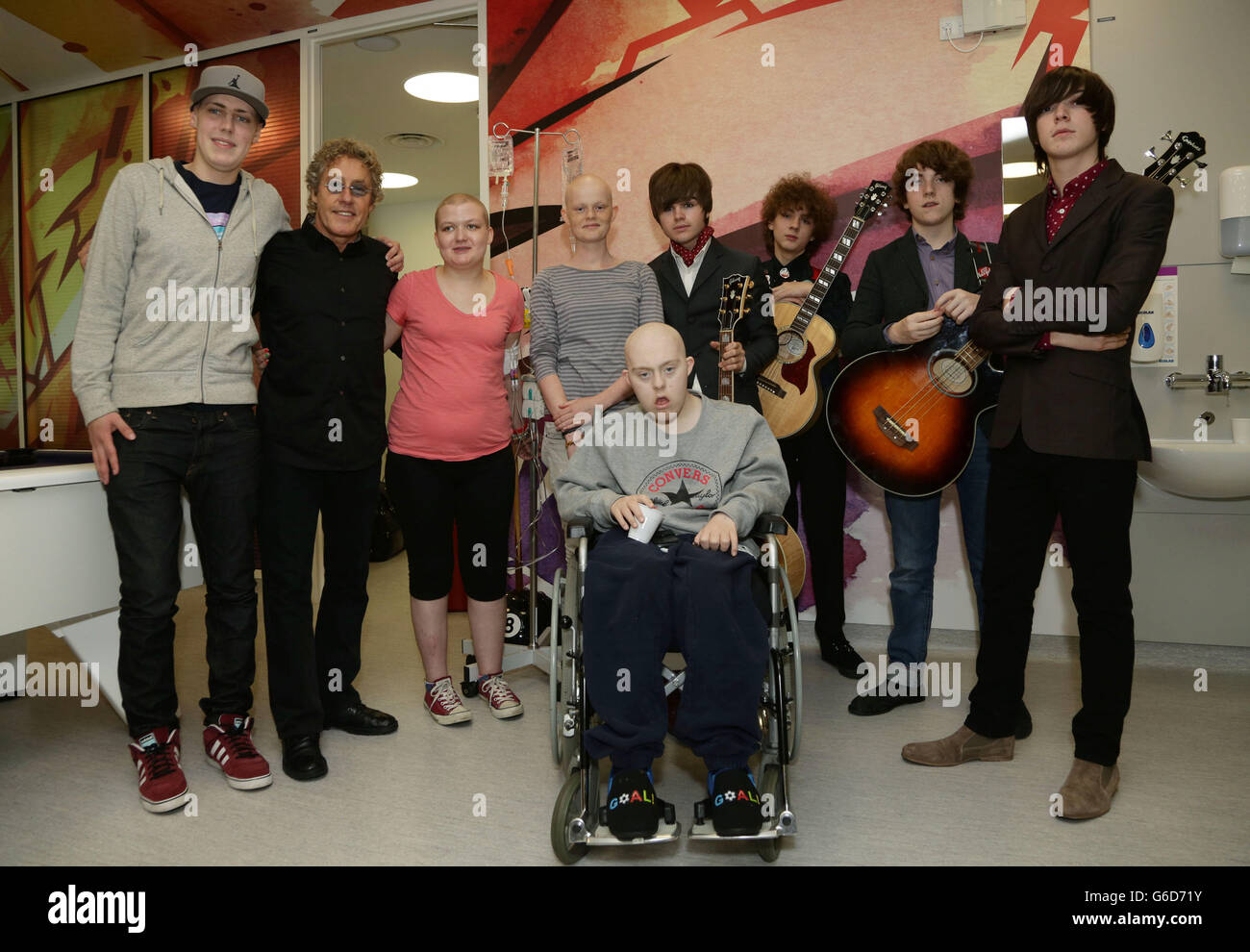 Roger Daltrey CBE (2nd left), Patron of Teenage Cancer Trust, with current patients Will Hunt (left), Heidi Smith (3rd left) Madaleine Zachry and Peter Londors, and new band The Strypes Josh McClorey (4th right), Evan Walsh (3rd right), Pete O'Hanlon and Ross Farrelly, during their visit and gig at a specialist Teenage Cancer Trust unit at University College Macmillan Cancer Centre, central London. Stock Photo