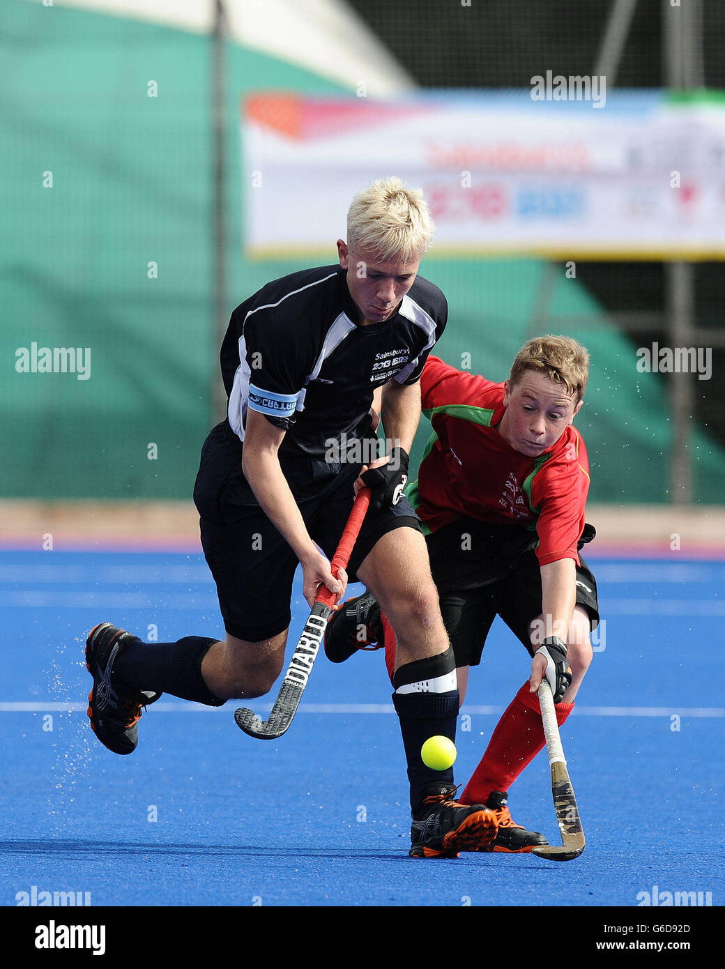 Scotland's Aiden McQuade is tackled by Wales' Tom Peters in the Boy's Hockey competition during day two of the 2013 Sainsbury's School Games at the Abbeydale Sports Ground, Sheffield. Stock Photo