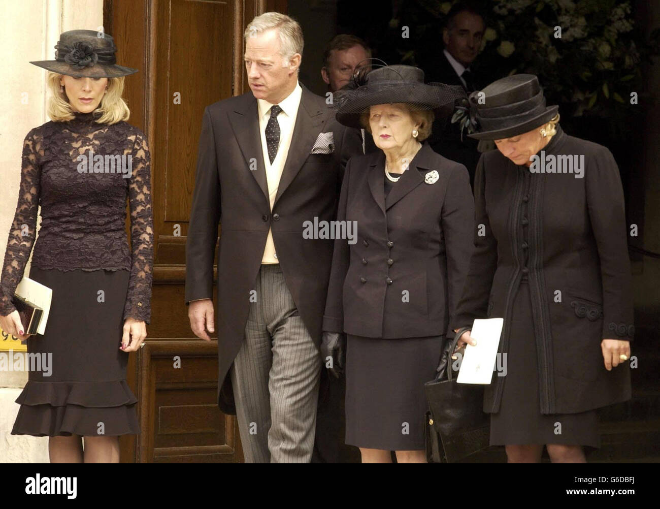 Former Prime Minister Baroness Thatcher (centre right) stands with her daughter Carol (right), her son Mark, and his wife Diane, as the coffin of her husband Sir Denis Thatcher is carried from the chapel at the Royal Hospital in Chelsea, west London. *... Sir Denis, 88, died in the Lister Hospital, London on June 26 after a short illness. In January he underwent a six-hour heart by-pass operation from which he seemed to be recovering, before falling ill again in mid-June. Stock Photo