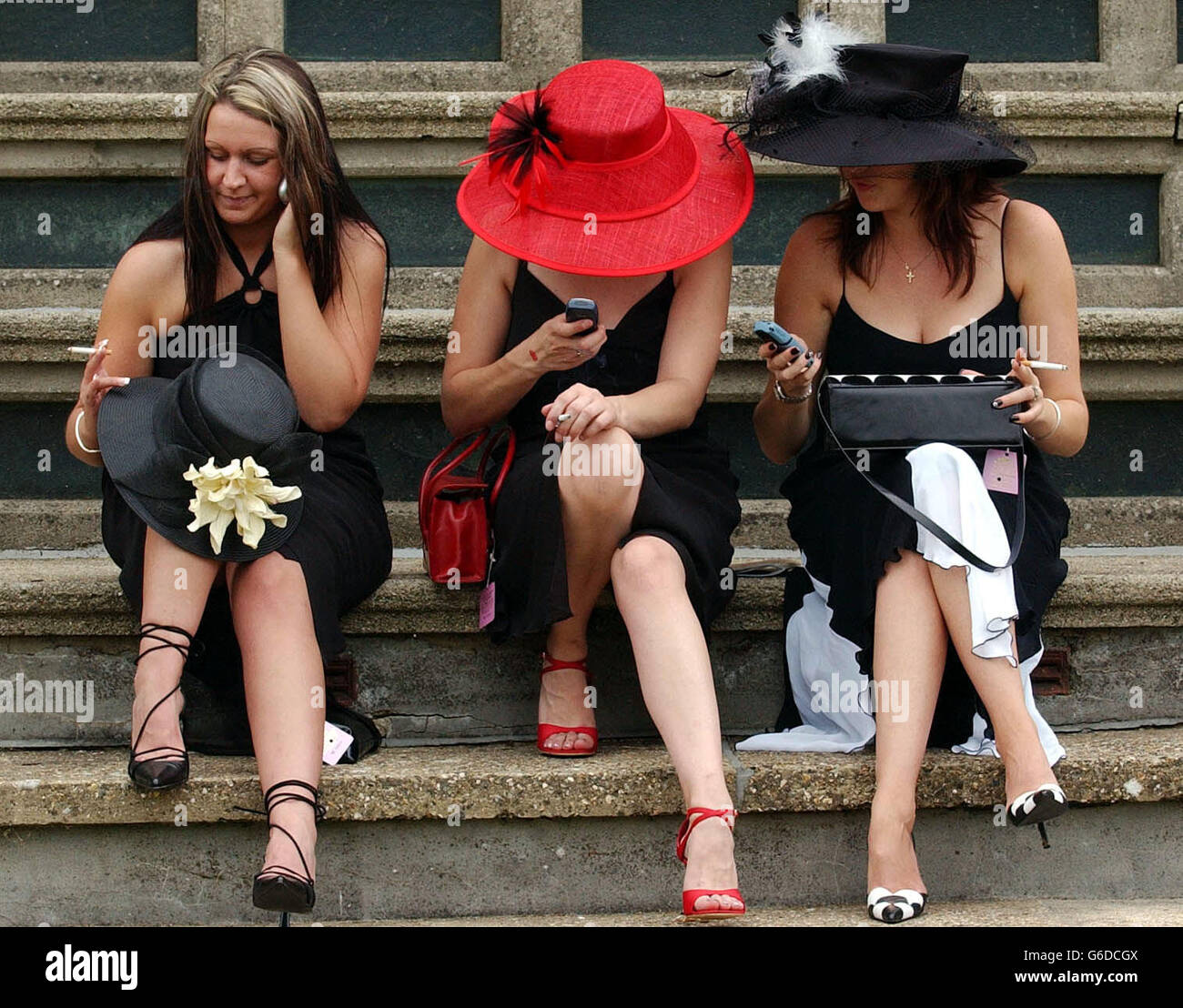 Racegoers at Newmarket Races. Racegoers at Newmarket appear to be more interested in phoning than racing. Stock Photo