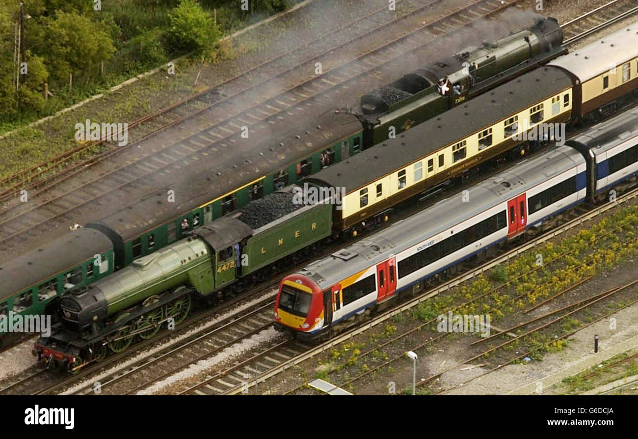 The Flying Scotsman (centre), pulling the Orient Express out of London towards Bath, passes the Cathedral Express, pulled by a 1955 Standard 5 engine number 73096, in Basingstoke. Stock Photo