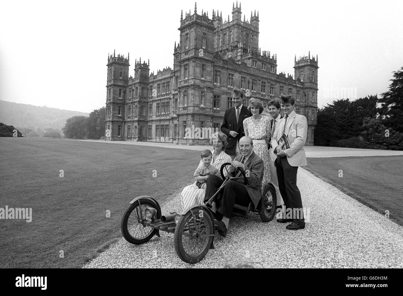 The Seventh Earl of Carnarvon sits in the 1922 family Red Bug Buckboard - believed to be the only one in the country - surrounded by members of his family at Highclere Castle, near Newbury, ready to welcome visitors when their home opens to the public for the first time on July 3. Standing, from left: Lord Porchester, 31, eldest son and heir; daughter Lady Carolyn Warren, 26, and her husband John, and son, Harry Herbert. The Countess of Carnarvon is holding her grandson Jake, son of Lady Carolyn. Stock Photo
