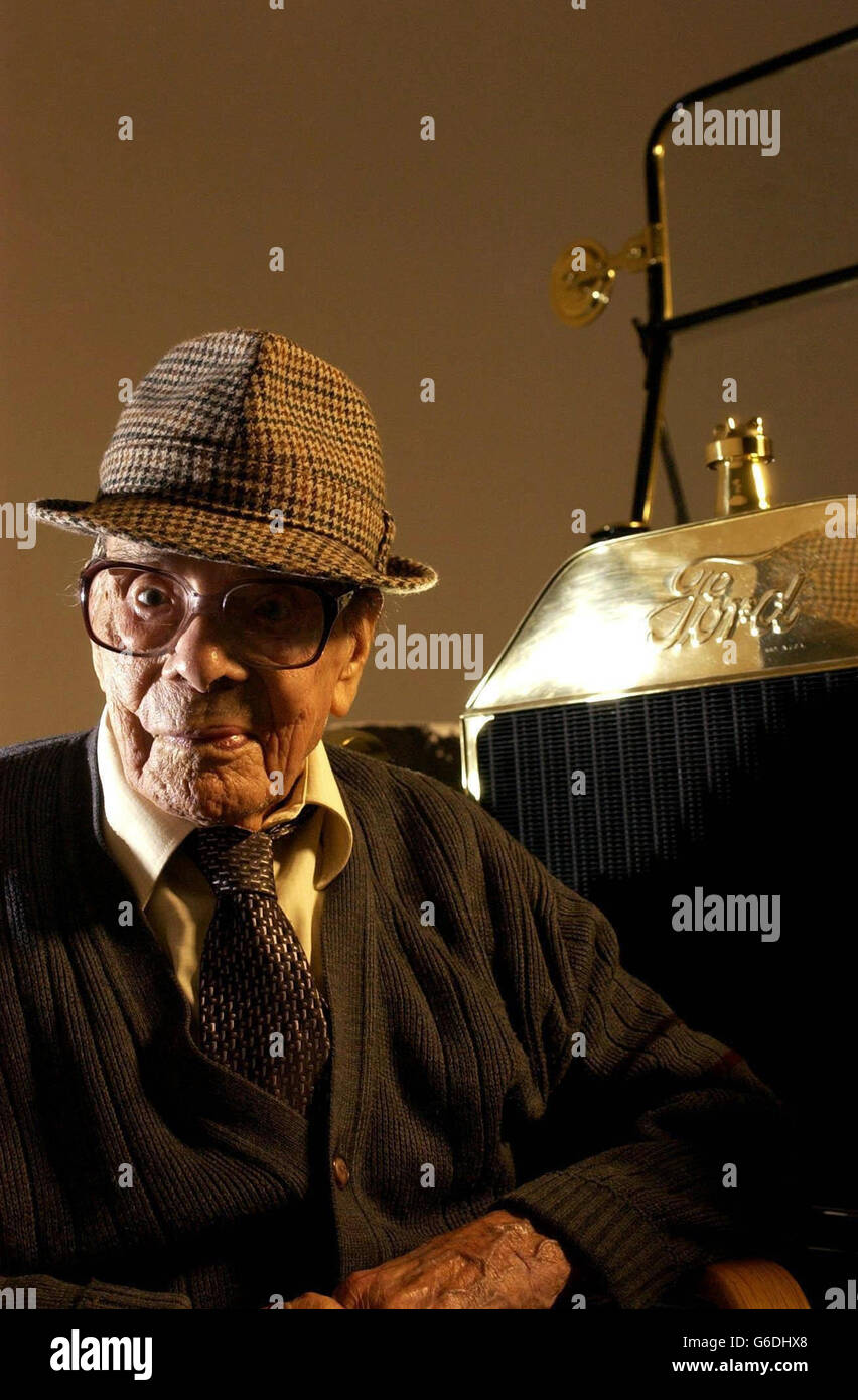 Centenarian Sid Curtis sits next to a Ford Model T car at the Ford Motor Plant in Aveley, Essex. Mr Curtis who worked for Ford nearly 50 years, celebrates his hundredth birthday in the same month as the famous automobile company, which reaches it's centenary. Stock Photo