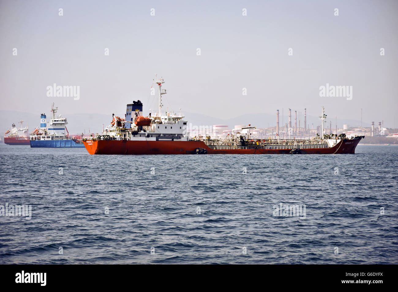 A general view of ships off the coast of Gibraltar with the industrial petro-chemical refinery, Puente Mayorga, Cadiz Province, Costa del Sol, Andalusia, Spain, Western Europe in the background. Stock Photo