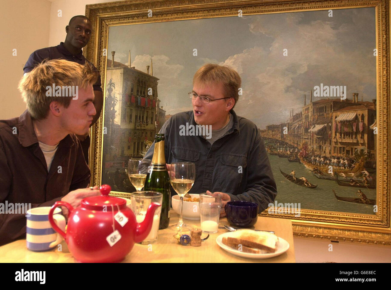 Art Student Ben Haworth (left) and his brother Alex enjoy breakfast in front of Canaletto's Regatta On The Grand Canal at their north London home. Ben, 22, who studies at Slade School of Art, and his brother Alex, 24, a sports agent, * .. won the Canaletto competition to hang the picture, worth millions of pounds, in their kitchen for the day as part of a six-week event to bring art out of its normal museum environment. The picture is on loan from Bowes Museum in County Durham. Stock Photo