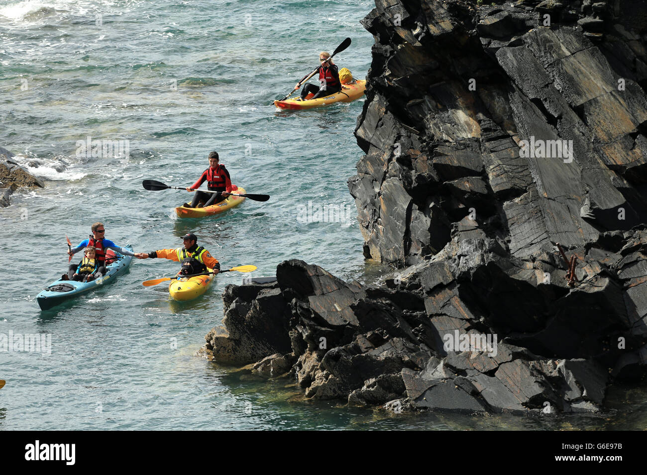 Canoeist make their way into the lagoon during day two of the Red Bull Cliff Diving World Series at the Blue Lagoon in Abereiddy. Stock Photo