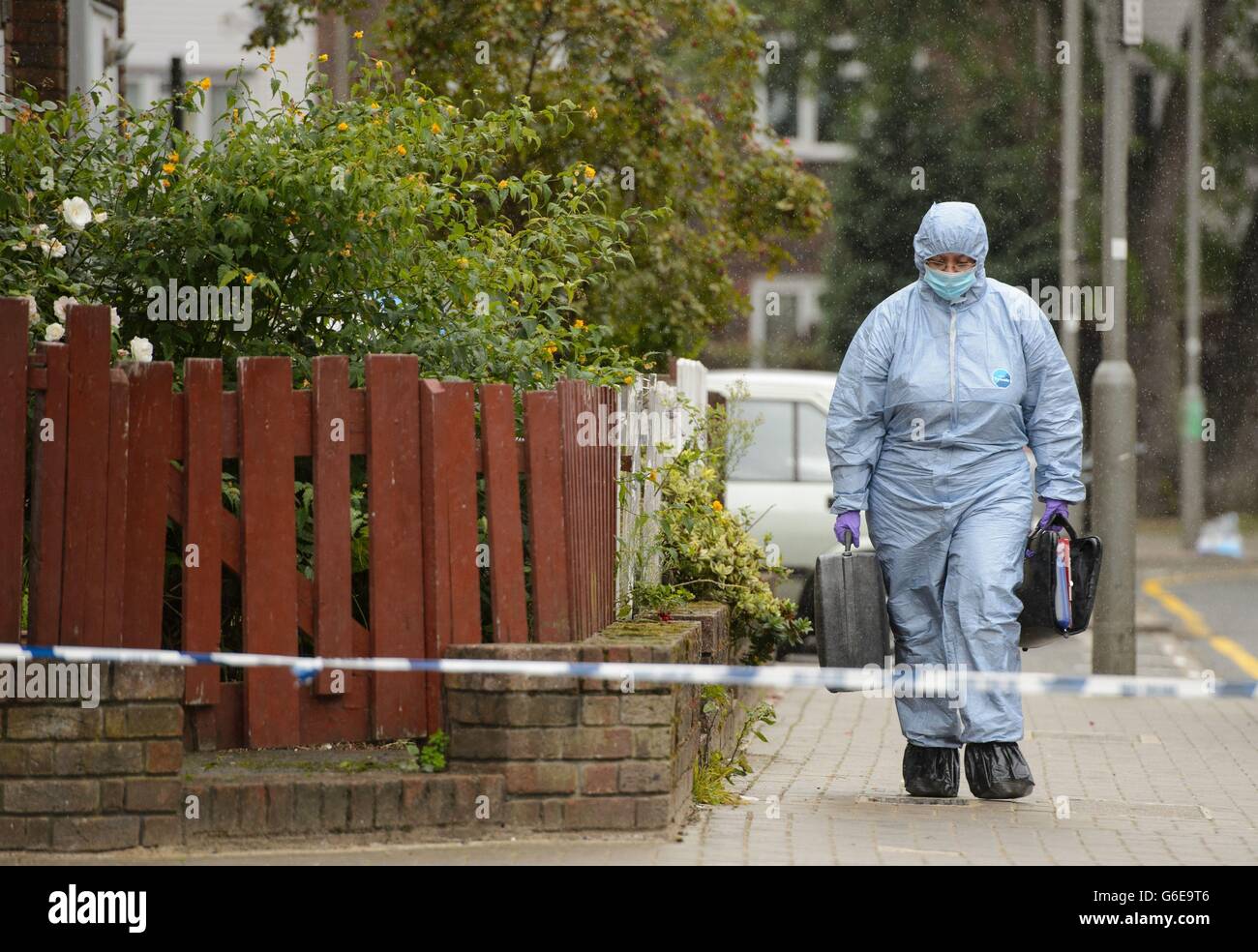 A police forensics officer at the scene where a 19 year old man was fatally shot last night, at Coppock Close, in Battersea, south London. Stock Photo