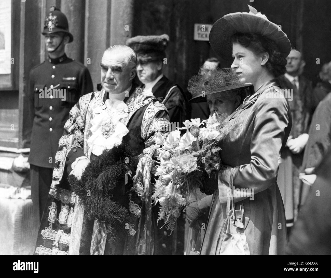 Crowds lined the route from Buckingham Palace to the Guildhall, London, to see the DUKE OF EDINBURGH accompanied by his wife PRINCESS ELIZABETH, escorted by an escort of the Household Gavalry, drive to the Guildhall where the DUKE received the Freedom of the City of London. He signed the role immediately under the name of PRINCESS ELIZABETH- the last person to sign it. PICTURE SHOWS: H.R.H.PRINCESS ELIZABETH, holds a bouquet of flowers, with the Lord Mayor of London, Sir FREDERICK WELLS, when she arrived with the DUKE OF EDINBURGH at the Guildhall. Stock Photo