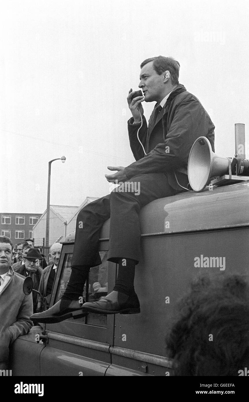 Seated on the roof of a van, Mr. Anthony Wedgwood Benn, the Minister of Technology, uses a loud hailer to address a factory-gate meeting at Rolls Royce Ltd. workers during his visit to bristol to see work in progress on the Anglo-French Concorde project. Speaking to the Rolls Royce workers as they left for their lunch break, the Minister said that 'if all goes well and the options taken out are converted into firm orders and world airliners make their orders firm, we shall see not only firm production of the production Concorde but a considerable gain in orders for us and for France.' Stock Photo