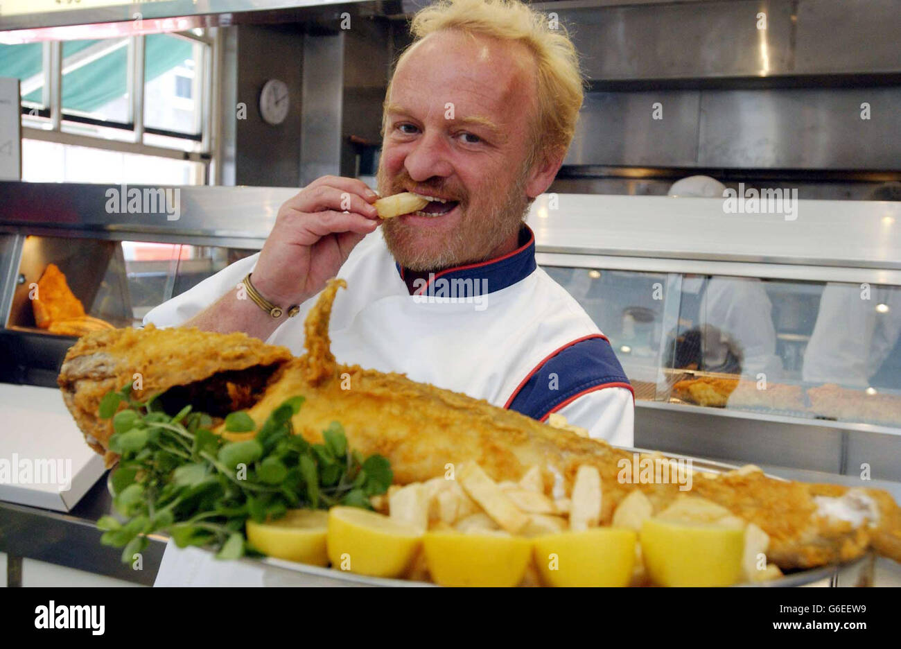 Celebrity chef Anthony Worrall Thompson samples the fish at The Seashell in Lisson Grove , north west London during the launch of the 16th annual Fish and Chip Shop of the Year Competition. * The competition organised by the Sea Fish Industry Authority (Seafish), to find the nation's best fish frier, reaches its climax early next year at a prestigious awards ceremony in London. 28/01/04: Ten fish and chip shops will find out which has won the title of the UK's top chippie. Celebrity chef Antony Worrall Thompson is due to announce the winner of the 16th annual Fish and Chip Shop of the Year Stock Photo