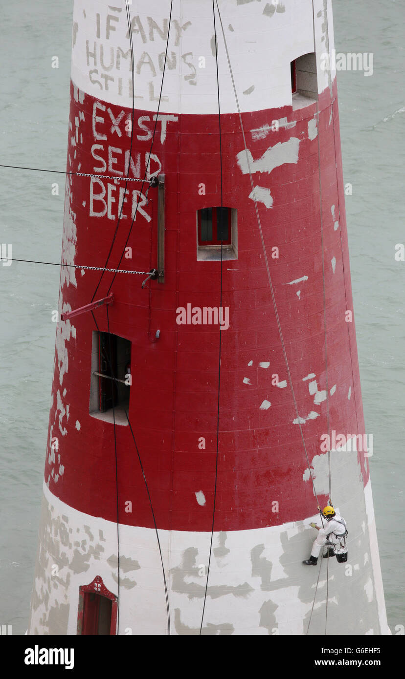 Specialist painters send a message to the outside world as they continue to live and work on Beachy Head Lighthouse near Eastbourne, Sussex, during the process of repainting the structure following a successful fund raising campaign to save the stripes. Stock Photo