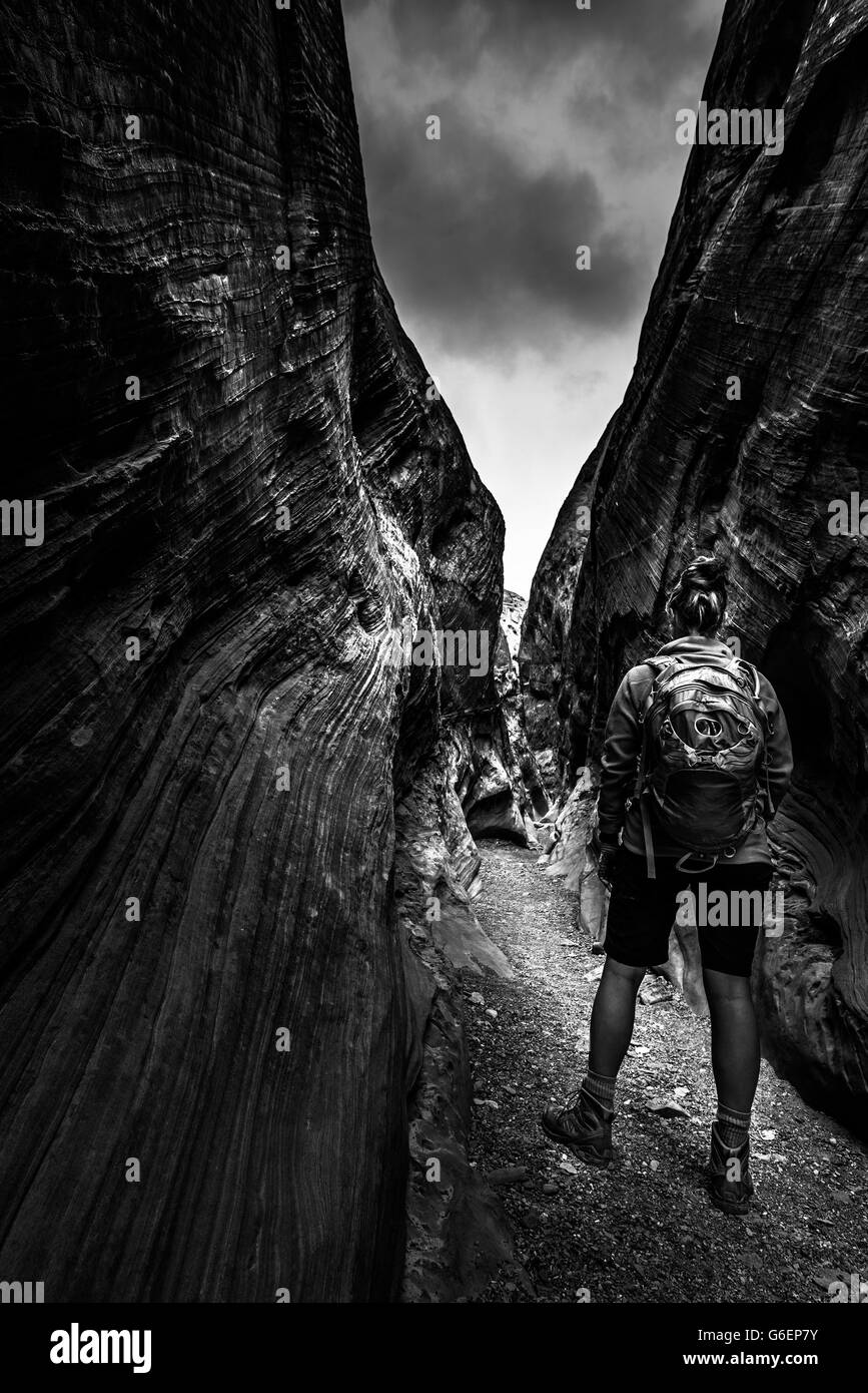 Hiker inside slot canyon Black and White hight contrast vertical composition Stock Photo