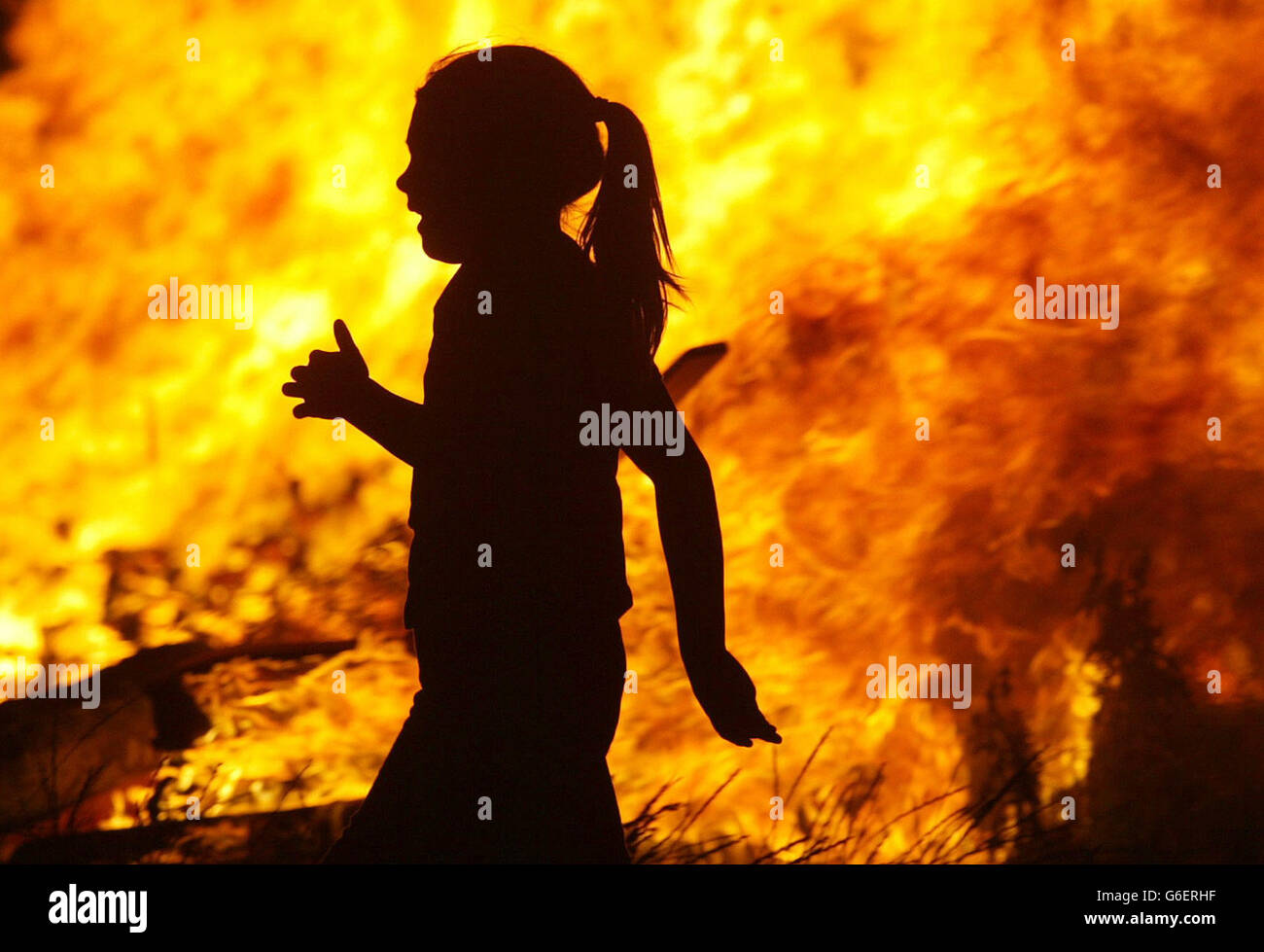 A young girl runs past a huge bonfire on Shankill Road, Belfast, one of