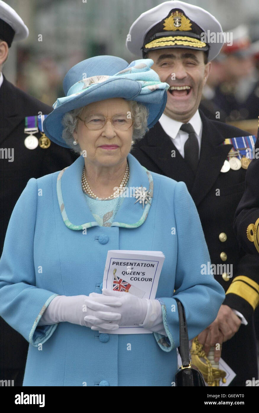 A laughing Rear Admiral James Rapp stands in parade behind Queen ...