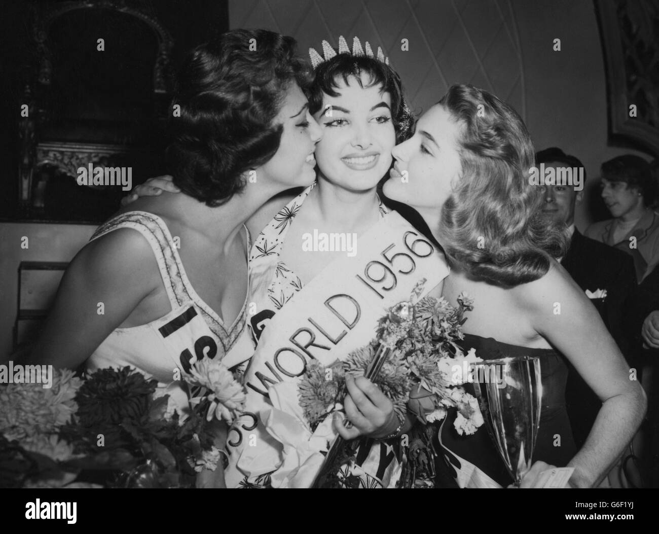 Petra Schurmann, of Germany, gets a victory salute from Miss World runners-up Betty Lane Cherry (r) and 'Miss Isreal' Rina Weiss, after winning the Miss World title in the final of the title Miss World 1956 contest held at the Lyceum, Strand, London. Betty Lane Cherry came second in the contest for the second year running and Rina was third. Stock Photo