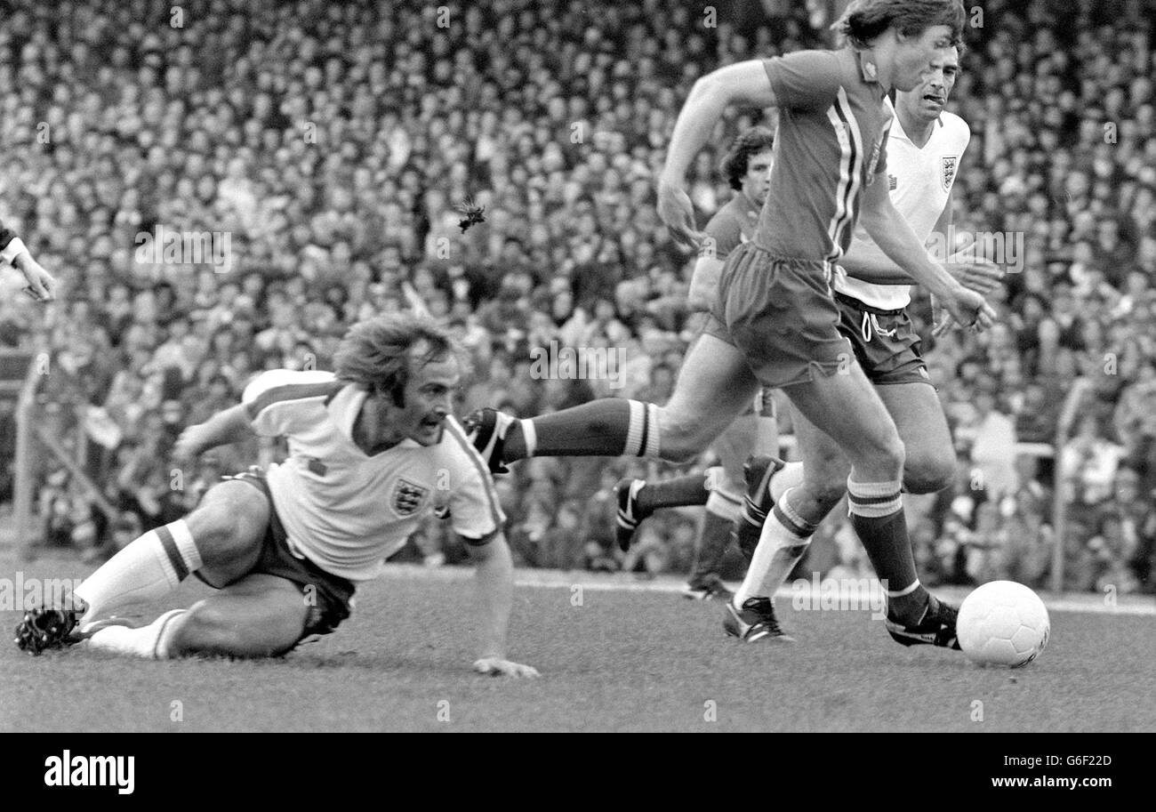 Mick Mills, the man who captained Ipswich in their FA Cup win over Arsenal, sits this one out at Ninian Park, as he watches England team mate Trevor Brooking (half hidden) close in on Carl Harris of Wales. It was a big occasion for Mills who captained the England international team to a 3-1 win over the Welshman. Stock Photo