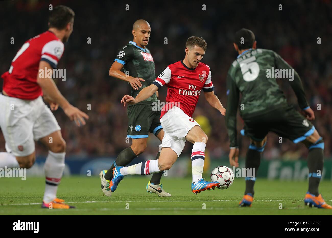 Soccer - UEFA Champions League - Group F - Arsenal v Napoli - Emirates Stadium. Arsenal's Aaron Ramsey attempts to run in between Napoli's Gokhan Inler (left) and Miguel Britos (right) Stock Photo