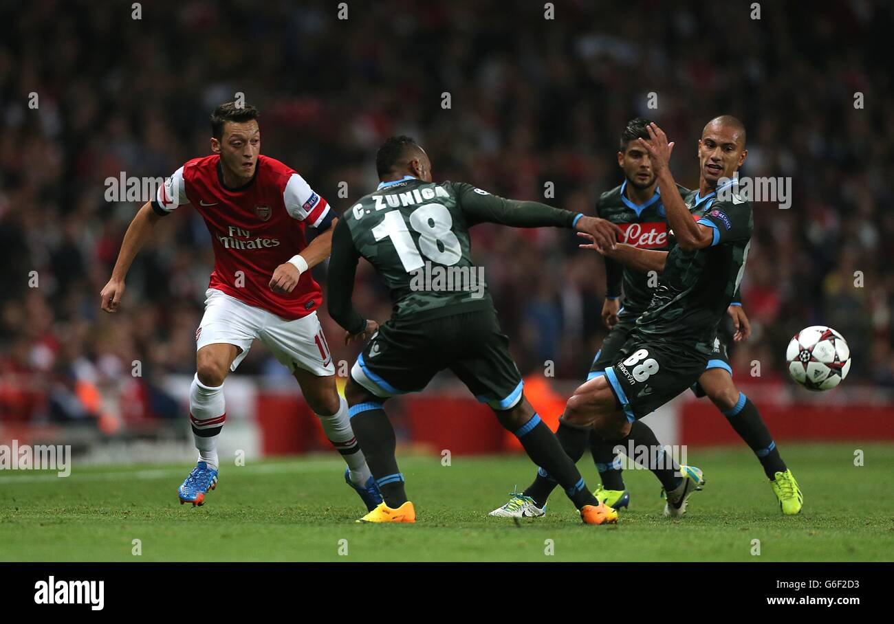 Arsenal's Mesut Ozil (left) battles for the ball with Napoli's Juan Zuniga (centre) and Gokhan Inler (right) Stock Photo