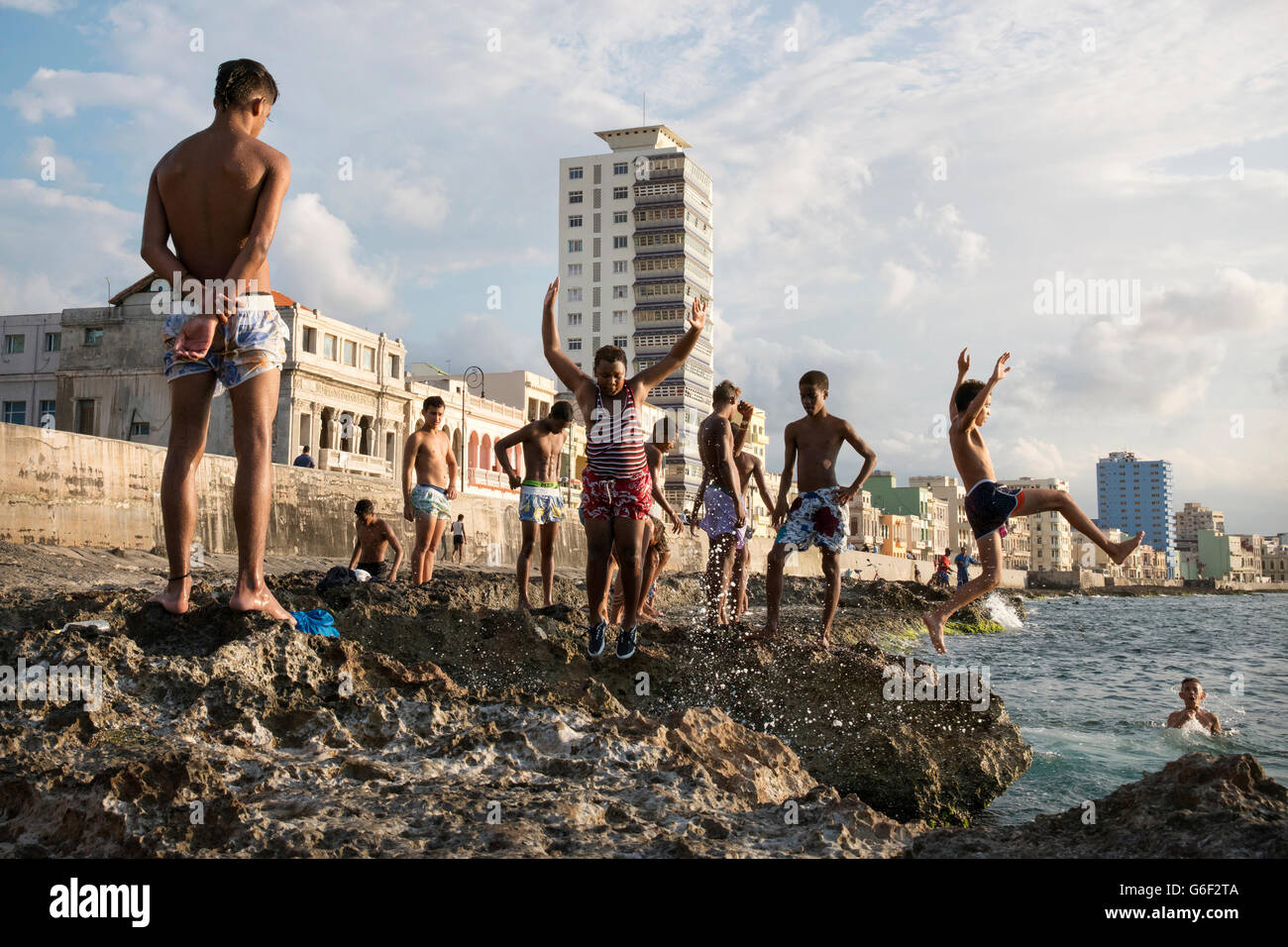 Local boys diving into the sea from the rocks in front of The Malecon (coast road) in Havana, Cuba Stock Photo